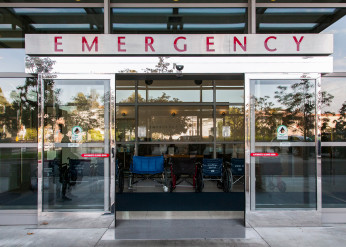 Automatic sliding doors under a sign reading Emergency