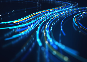 Bright blue lines of lit fiber optic cables curve around on a dark background