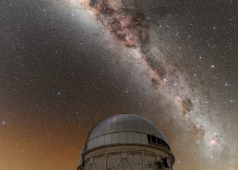 The Milky Way shines over the dome of an observatory