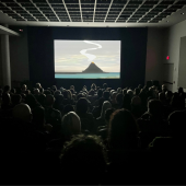 Darkened cinema with audience watching a film.