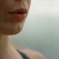The lower half of a woman's face shows an exhaling mouth