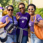 Three women in Northwestern shirts pose doing the Wildcat claw